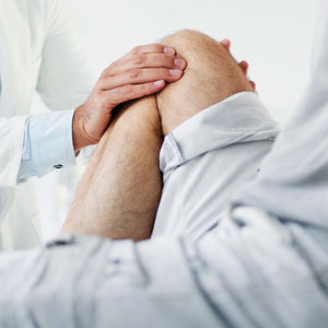Doctor working with patient on knee pain