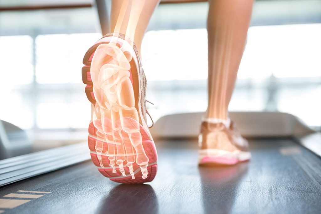 Highlighted foot of woman on treadmill.